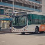 Ônibus urbano parado em um ponto enquanto passageiros embarcam.