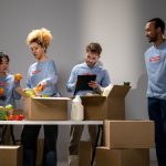 Voluntários organizam e embalam doações de alimentos em um espaço interno