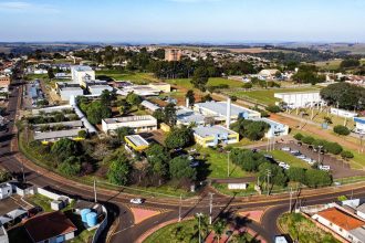 Vista aérea de um campus universitário, com edifícios acadêmicos e áreas verdes ao redor.