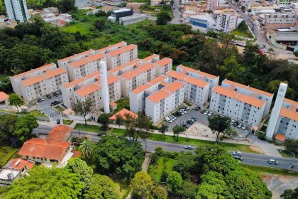 Vista aérea de um conjunto residencial de apartamentos cercado por áreas verdes.