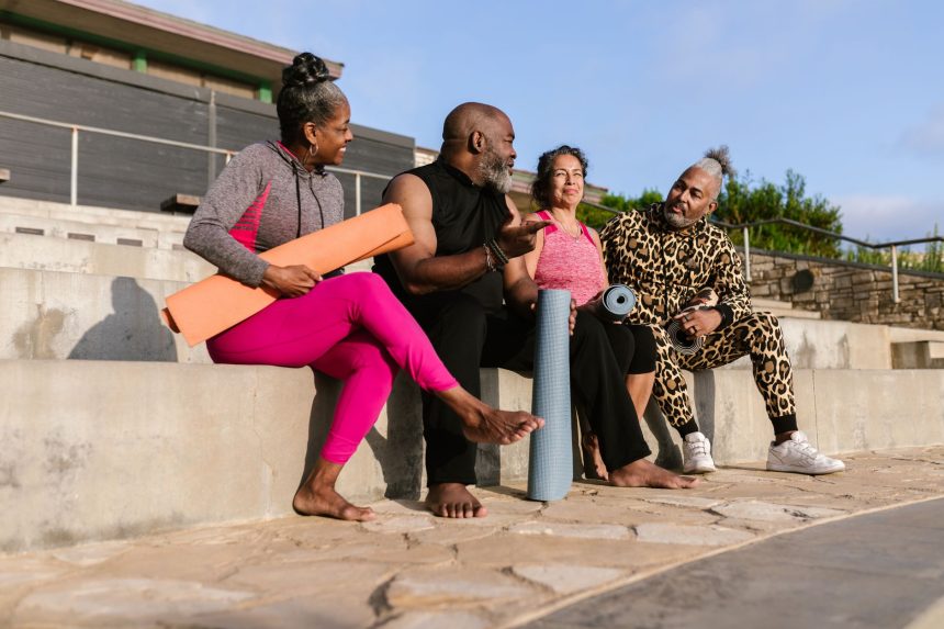 Grupo de idosos reunido ao ar livre, com colchonetes de yoga, durante uma atividade de bem-estar.